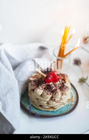 Tradizionale delizioso tiramisù e candele in background Foto Stock