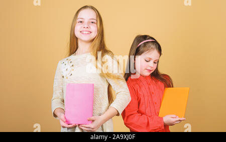 Sorelle pick libri da leggere insieme. Adorabili ragazze amano i libri. Diari segreti o un diario personale. Smart è grande. I ragazzi ragazze con libri e quaderni. Educazione e letteratura per bambini. Favola preferita. Foto Stock