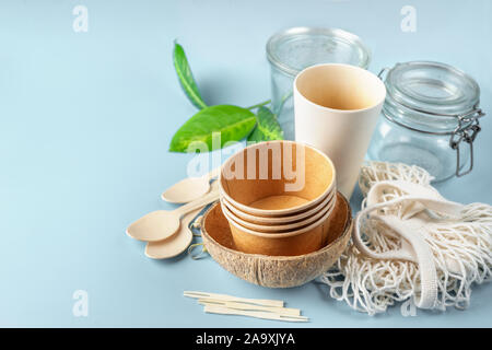 Eco posate su fondo azzurro. Carta e tazze di bambù, borsa e posate in legno Foto Stock