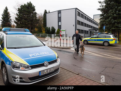 Brand Erbisdorf, Germania. Xviii Nov, 2019. Un poliziotto lascia Brand-Erbisdorf (FBAB) con il suo cane poliziotto alla formazione e formazione professionale Academy GmbH. La scuola di formazione professionale nel centro città sassone di Brand-Erbisdorf è stato evacuato il lunedì dopo una minaccia. Credito: Robert Michael/dpa-Zentralbild/dpa/Alamy Live News Foto Stock