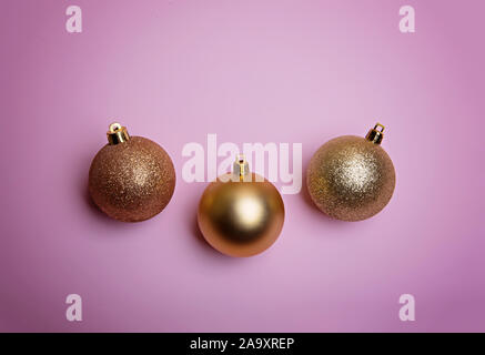 Golden palle di Natale su una rosa pallido sfondo. Flatlay. Vista da sopra. Foto Stock