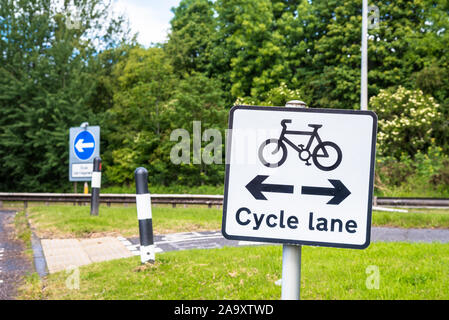 Segno lungo una strada che indica un incrocio con una pista ciclabile. Il percorso del ciclo è visibile in background. Foto Stock