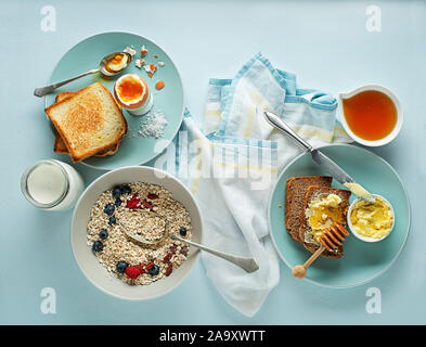 Ristorante e bar Colazione La colazione è servita con i fiocchi d'avena e frutta, uova sode, miele e burro. La deliziosa colazione sana. Foto Stock