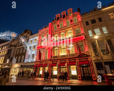 Luci festive in New Bond Street di notte con la facciata rossa di Cartier, Mayfair, Londra. Foto Stock