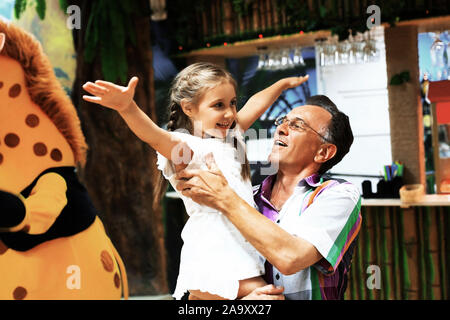 Nonno giocando con il nipote in un centro di intrattenimento Foto Stock