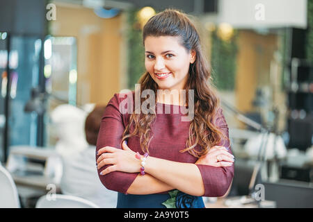 Affascinante giovane donna sorridente proprietario del salone di bellezza nail bar, il concetto di una piccola impresa Foto Stock