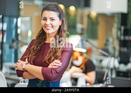 Affascinante giovane donna sorridente proprietario del salone di bellezza nail bar, il concetto di una piccola impresa Foto Stock