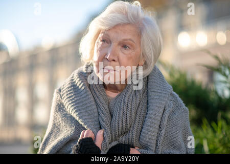 Close up di età compresa tra i senzatetto donna che indossa un maglione Foto Stock