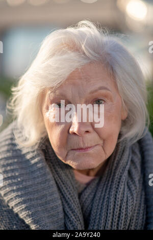 Di età compresa tra i senzatetto donna con le rughe del viso sentirsi protetti Foto Stock