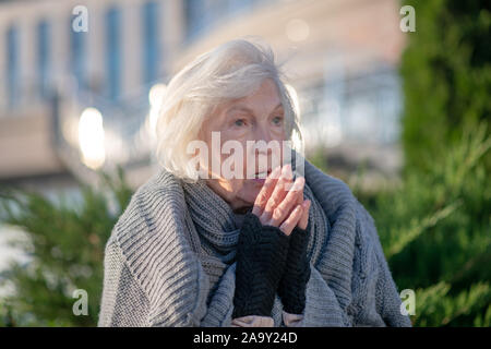 Blue-eyed senzatetto pensionato sensazione di miserabili e di fame Foto Stock