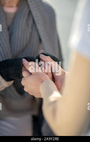 Close up di volontari provenienti e supporto di povera donna senzatetto Foto Stock