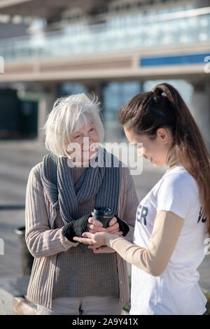 Senzatetto titolare di pensione o di rendita una buona sensazione mentre si parla con il volontario Foto Stock