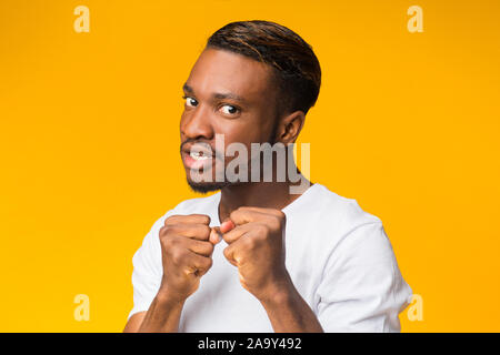 Ragazzo nero Clenching pugni pronti a lottare in piedi, Studio Shot Foto Stock