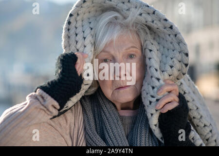 Blue-eyed senzatetto pensionato sensazione molto freddo e non protetti Foto Stock