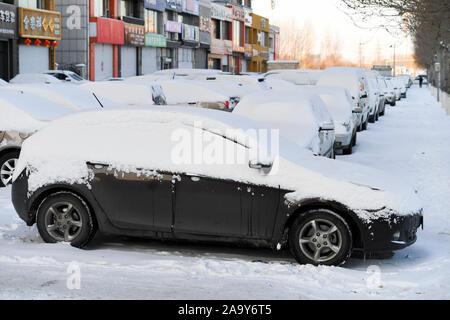 Le automobili sono coperti di neve sul ciglio della strada dopo una nevicata dal fronte freddo in Changchun City, norhteast cinese della provincia di Jilin il 18 novembre Foto Stock