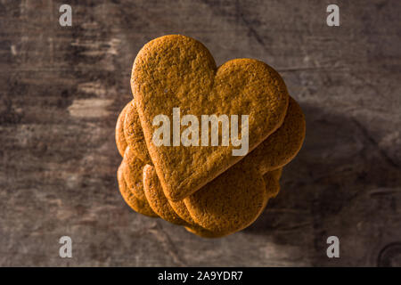 A forma di cuore ad cookie sul tavolo di legno. Il giorno di San Valentino e la Festa della mamma concetto.Vista dall'alto. Foto Stock