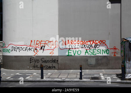 La Paz, Bolivia, 18th Ottobre 2019. 'Democrazia. Libertà. Narco dittatore, No dittatura, Evo killer, Evo Sanchez de Lozada 'graffiti sul muro di costruzione nel centro di la Paz. La Bolivia ha tenuto le elezioni presidenziali il 20th ottobre, un'indagine successiva da parte dell'OAS ha confermato un gran numero di irregolarità e il presidente Evo Morales si è dimesso il 10th novembre. Foto Stock