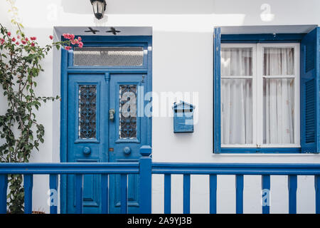 Facciata di un tipico Mykoniano casa bianca con portone blu e dettagli, Mykonos, Grecia. Foto Stock