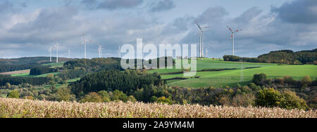 Le turbine eoliche e cornfield in tedesco eifel sotto nuvoloso cielo autunnale in Germania Foto Stock