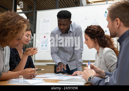 Concentrato African American team leader a discutere i risultati con i colleghi. Foto Stock
