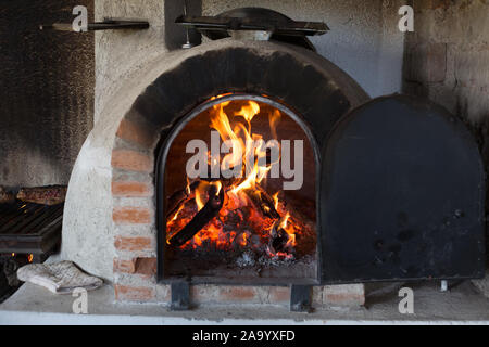 Il fuoco brucia in un legno forno a pizza. Foto Stock