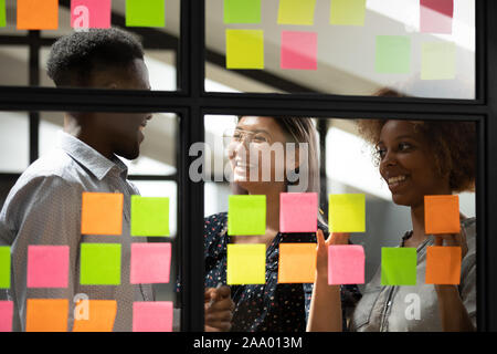 Sorridente dipendenti utilizzando gli strumenti di gestione per la pianificazione del lavoro. Foto Stock