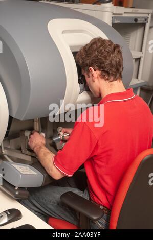 Close-up, dal retro, di merlano Scuola di studente di ingegneria con un chirurgico da Vinci il robot controlla per eseguire una simulazione di funzionamento presso la Johns Hopkins University, Baltimora, Maryland, Aprile 6, 2009. Dall'Homewood raccolta di fotografie. () Foto Stock