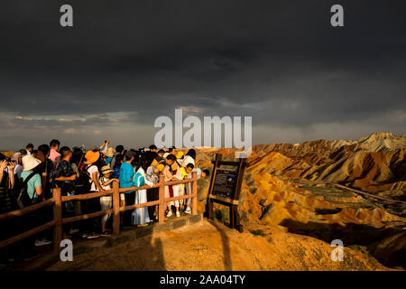 I turisti cinesi di visitare l'Arcobaleno montagne di Zhangye Danxia nazionale parco geologico Foto Stock