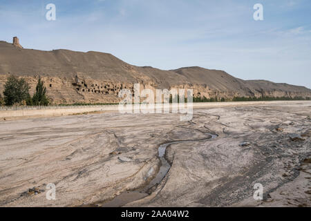 Fiume di fronte alla scogliera dove il buddista grotte di Mogao furono scavate Foto Stock