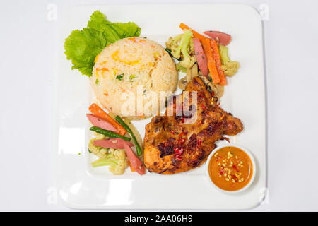 Un piatto di riso fritto, caldo picchetto di pollo con la salsa e miscelati vegetabls thai. Vista dall'alto. Foto Stock