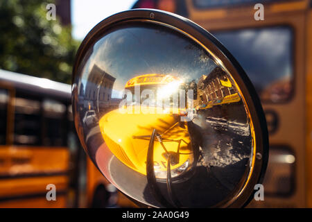 La riflessione di un bus di scuola in uno specchio retrovisore Foto Stock