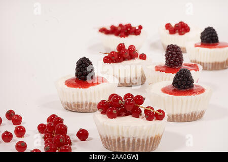 In casa la cheesecake decorate con ribes e mirtillo su sfondo bianco Foto Stock