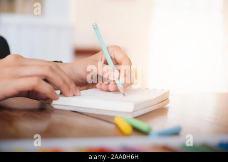 Close up mani femminili con penna scrittura su notebook. Il concetto di istruzione. Foto Stock