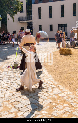 Bautzen, Germania - 1 Settembre 2019: Il ragazzo lancia enormi bolle di sapone. Ricostruzione storica presso la Old Town Festival di Bautzen, Lusazia superiore Foto Stock