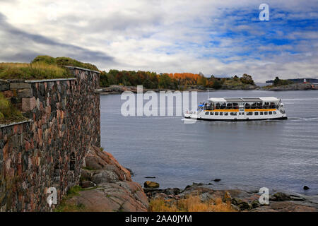 Piccolo traghetto viaggia vicino Kustaanmiekka, Suomenlinna fortezza sul mare in autunno. A Helsinki, Finlandia, ottobre 2019. Foto Stock