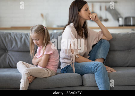 Sconvolto ragazza seduta di schiena con delusa madre. Foto Stock