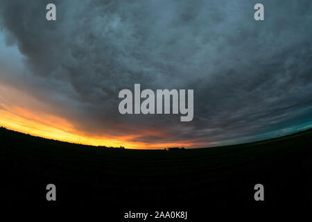 Vista fisheye del un drammatico cielo sopra il vasto paesaggio olandese vicino al tramonto. Bellissimi colori e texture del cielo. Foto Stock