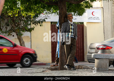 Fez, in Marocco. Il 9 novembre 2019. Un uomo vecchio sotto un albero in un quadrato Foto Stock
