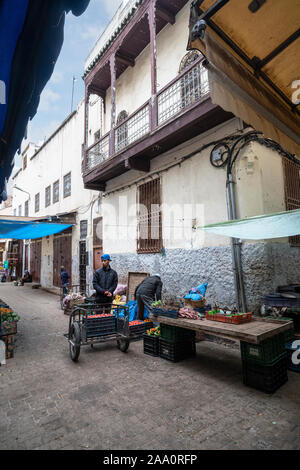 Fez, in Marocco. Il 9 novembre 2019. Un uomo con un carrello tra le bancarelle di frutta e verdura del mercato di strada nel vecchio quartiere ebraico Foto Stock