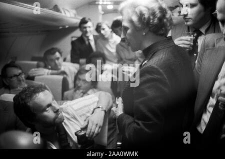 Sig.ra Margaret Thatcher, Inghilterra, circa giugno 1983. Campagna elettorale generale, durante il volo notturno di ritorno da Fleetwood, Lancashire, dove era stata campagna elettorale. La onorevole Thatcher parla con i membri della stampa itinerante. Il fotografo Herbie Knott la guarda in alto. OMERO SYKES Foto Stock