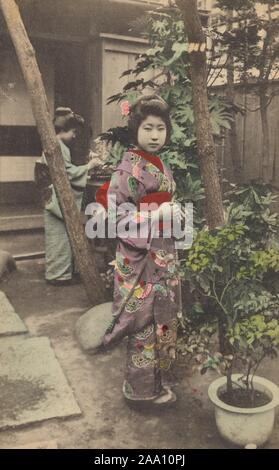 Cartolina illustrata di due maiko vestito in un tradizionale giapponese abiti kimono che lavorano nel loro giardino, Giappone, 1910. Dalla Biblioteca Pubblica di New York. () Foto Stock