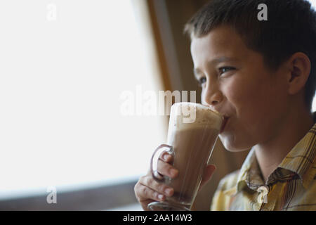 Ragazzo beve una cremosa cioccolata ghiacciata. Foto Stock
