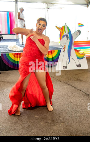 Indossa un rosso abito sequined, una drag queen doffs sua parrucca dopo la divertente a County Fair LBGTQ evento in Costa Mesa, CA. Foto Stock