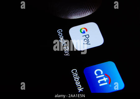 Google Pay e Citibank app su smartphone con la punta di un dito su Google Pay. A titolo illustrativo per Google e la Citibank di partenariato. Messa a fuoco selettiva Foto Stock