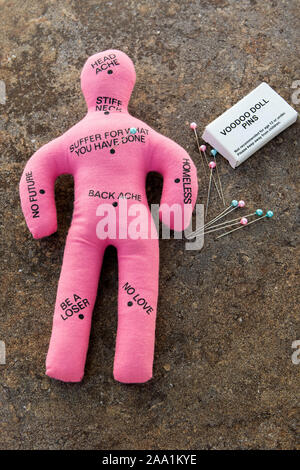 Pink Voodoo Doll con libri del voodoo spine o aghi Foto Stock