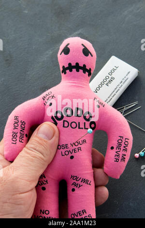 Pink Voodoo Doll con libri del voodoo spine o aghi Foto Stock