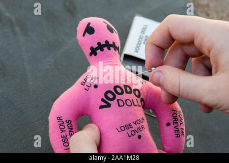 Pink Voodoo Doll con libri del voodoo spine o aghi Foto Stock