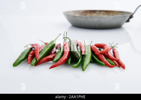 Close up, raccolta di rosso e peperoncini verdi con padella, preparazione alimentare, cucina casalinga, aroma ingrediente, still life Foto Stock