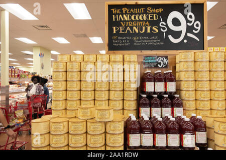 Un display di conserve handcooked Virginia arachidi e wassail all'interno di Trader Joe's, Wichita, Kansas, Stati Uniti d'America. I clienti in background. Foto Stock