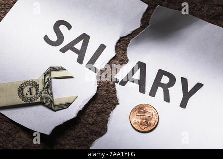 Un foglio di carta con le parole lo stipendio strappata a metà. Il concetto di crisi finanziaria. Non vi sarà alcuna retribuzione Foto Stock